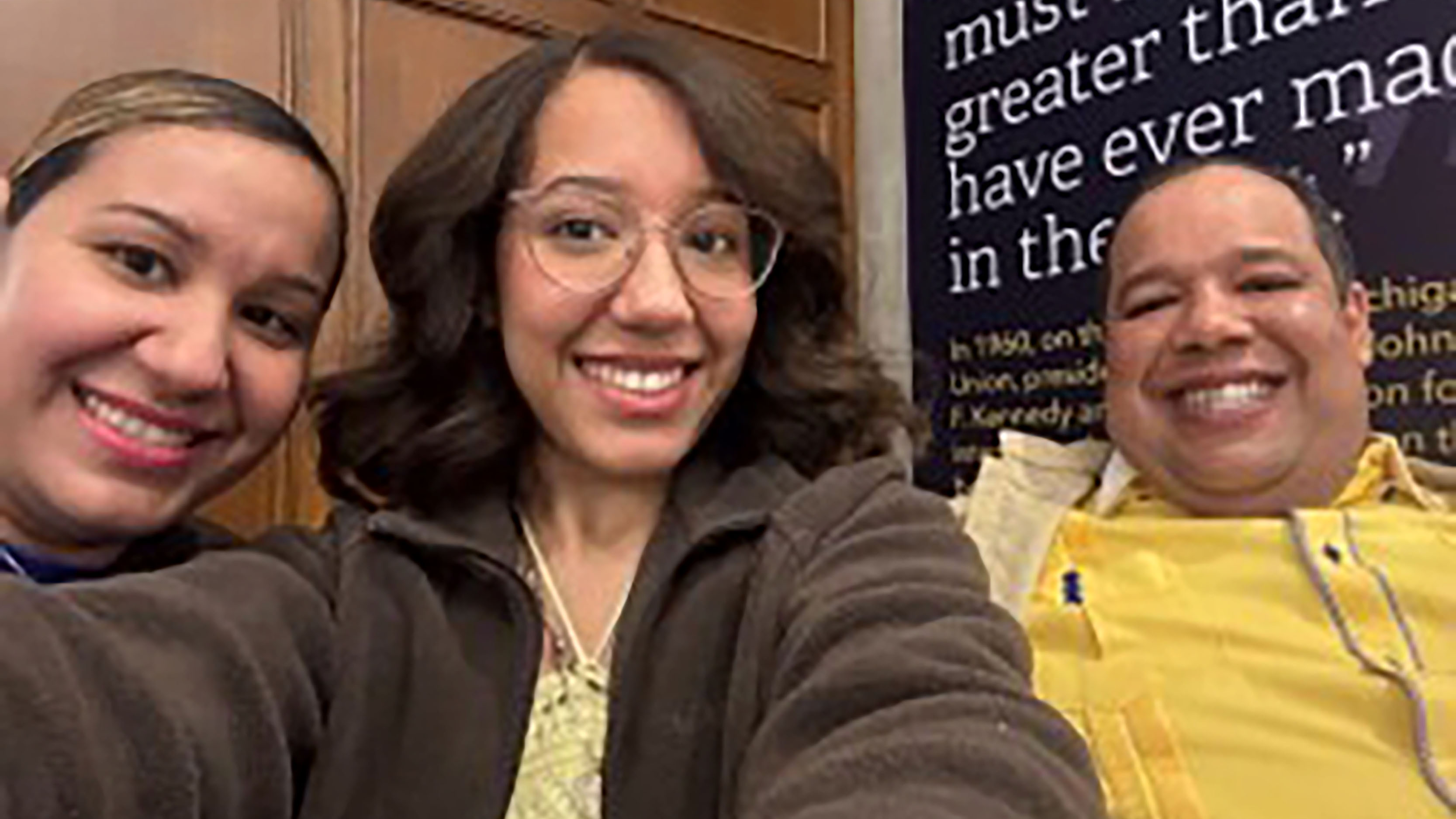 Two women and a man posing for a photo together