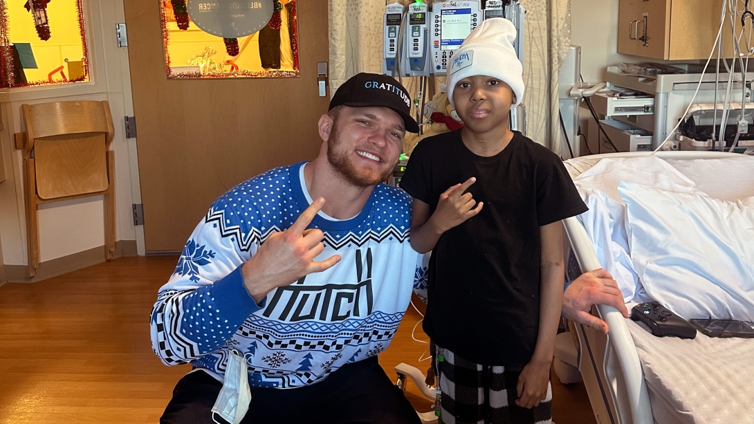 Aidan Hutchinson and Elijah Dottery in a hospital room.
