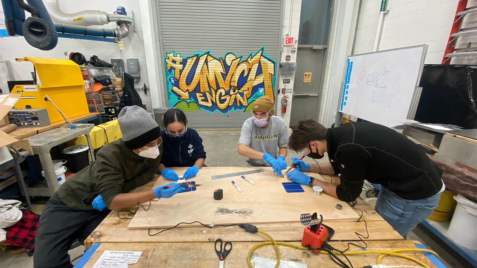 Students in an engineering lab soldering.