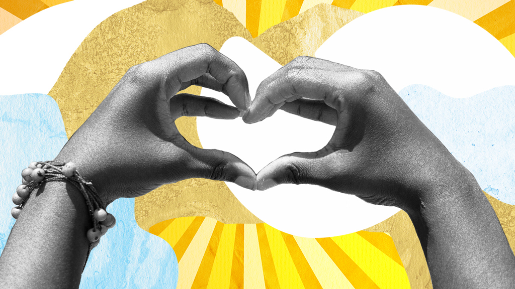 Black and white hands making a heart in front of a yellow and blue background.