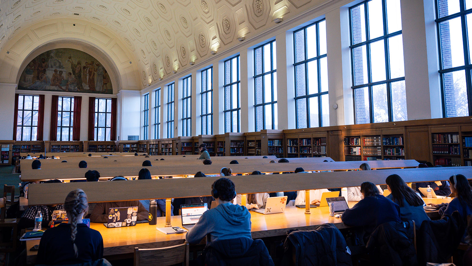 Students studying at long tables in a grand hall at Michigan.