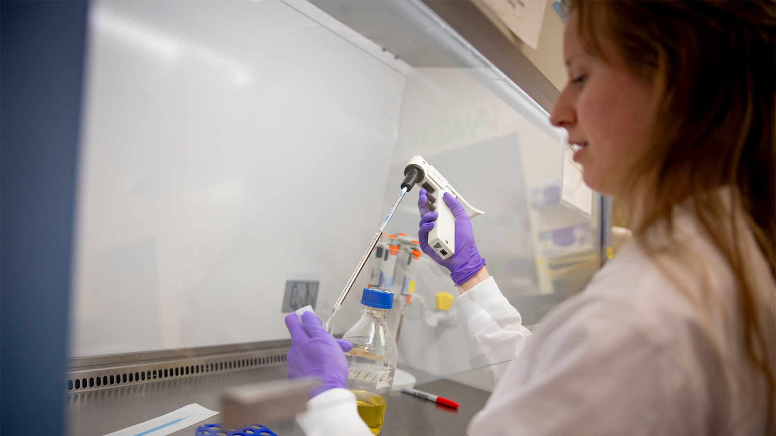 A woman in a lab coat working in a lab.