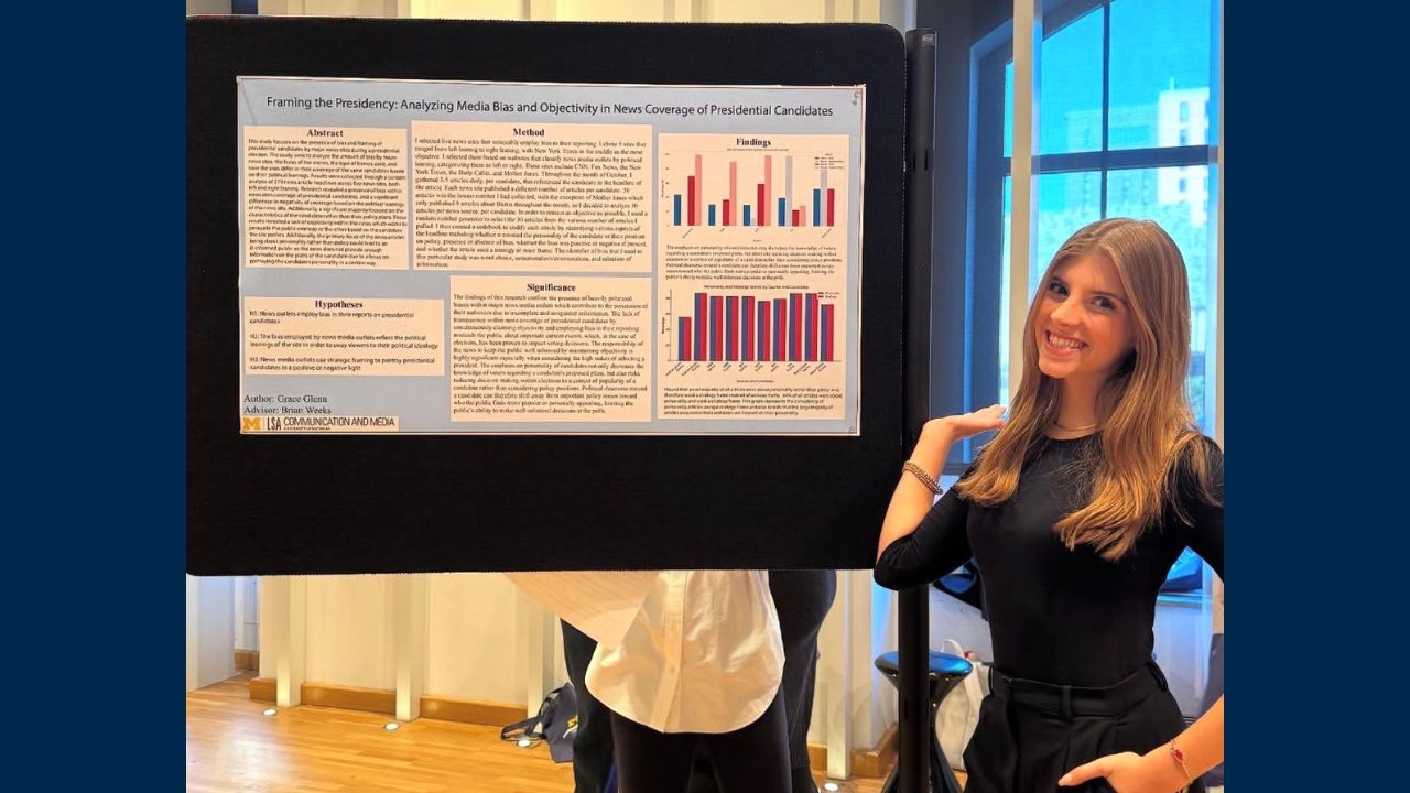 A student shows off a poster titled 'Framing the Presidency: Analyzing media bias and objectivity in news coverage of presidential candidates'
