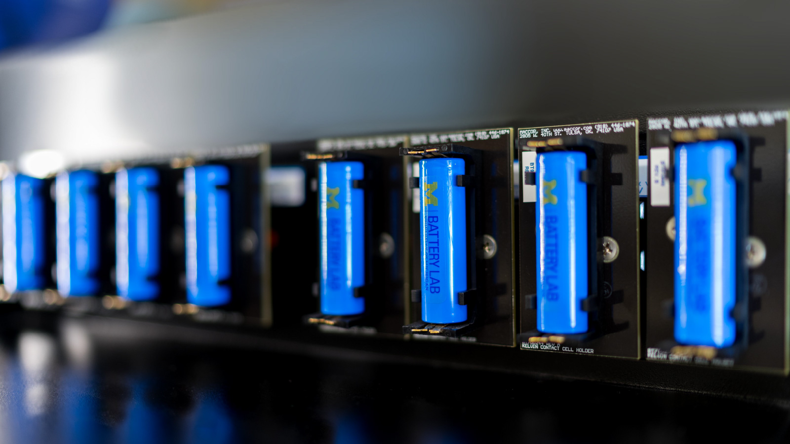 A row of cylindrical batteries with Michigan Battery Lab branding printed on them.