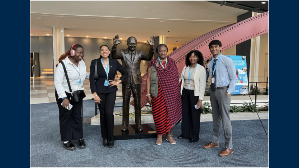 Students pose with a statue of Nelson Mandela at the United Nations General Assembly