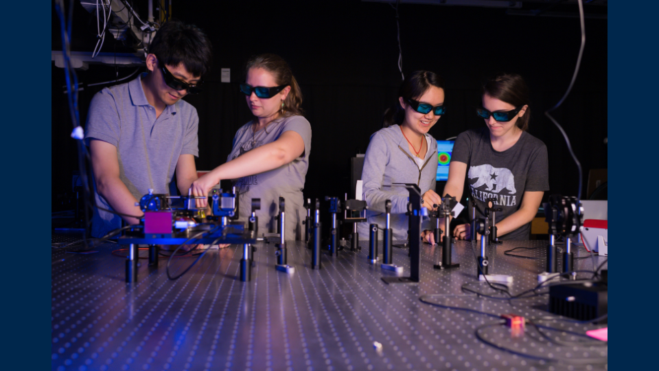 Physics students wearing safety goggles perform experiments 