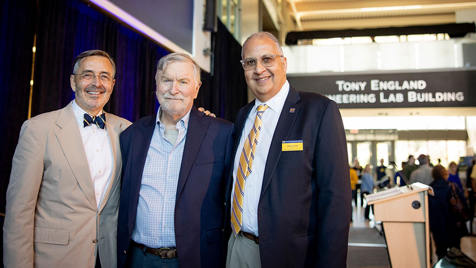 UM-Dearborn Chancellor Domenico Grasso (left), former College of Engineering and Computer Science Dean Tony England, and current CECS Dean Ghassan Kridli standing in front of a sign saying Tony England Engineering Lab Building.