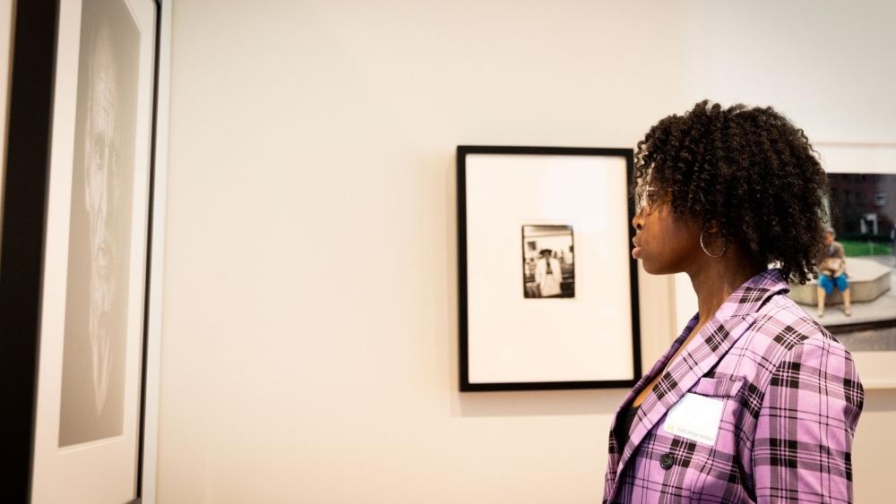 A U-M student contemplating a photo in the art museum.