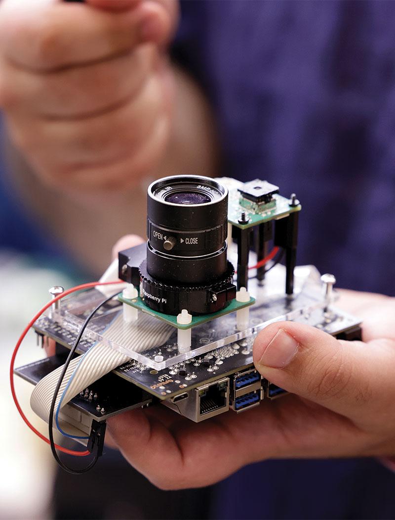 A close-up portrait of a person’s hands; one hand is holding a camera.