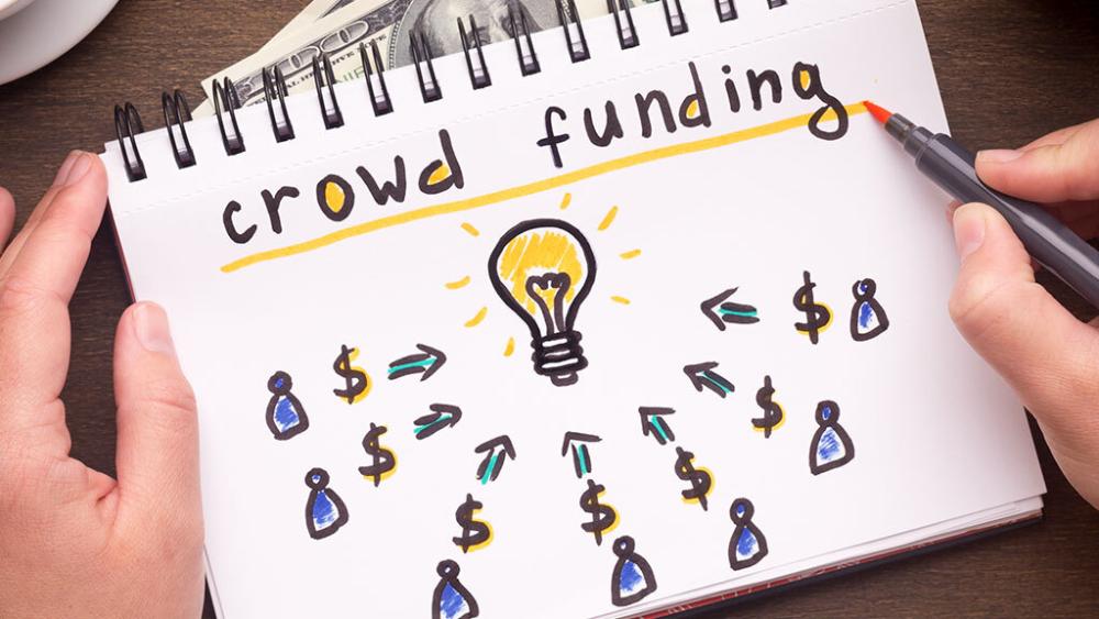 A notepad with an illustration representing crowd funding.