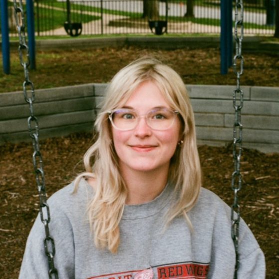 Lilllian Pearce sits on a swing in a playground