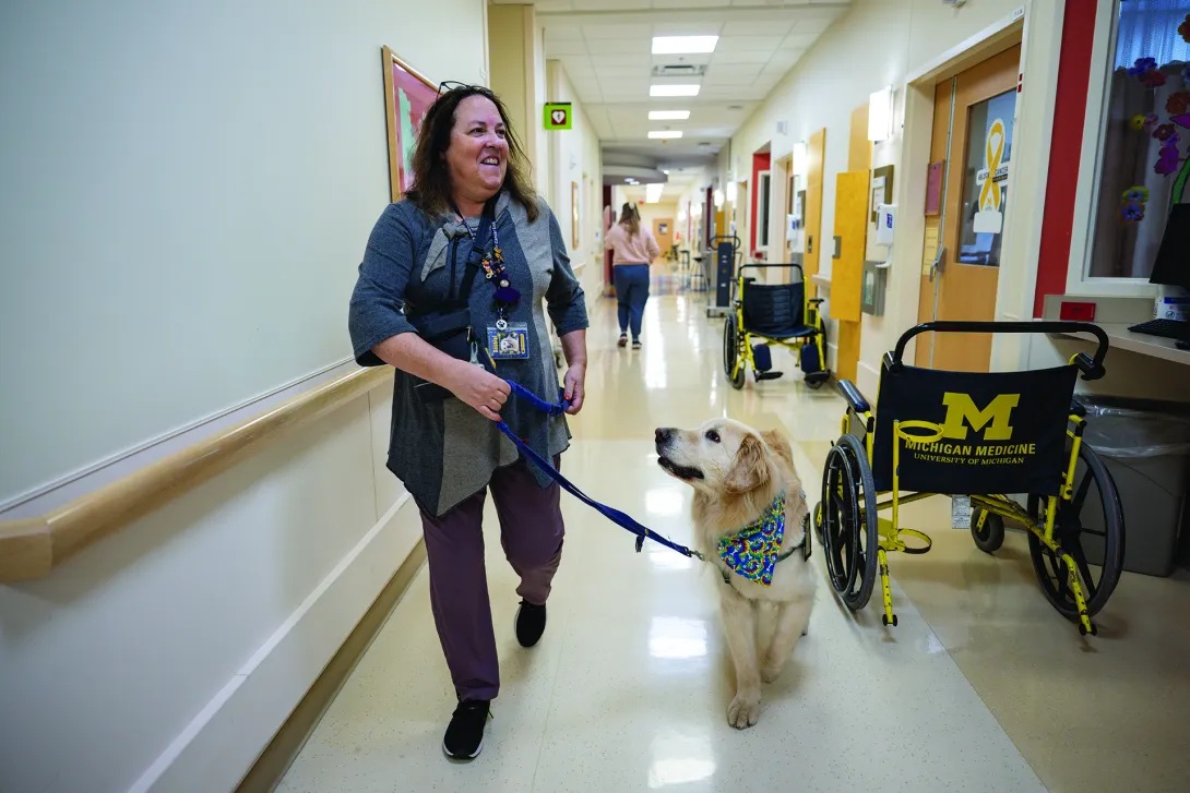 Mary Breakey walks a golden retriever through the halls at C.S. Mott Children's Hospital.