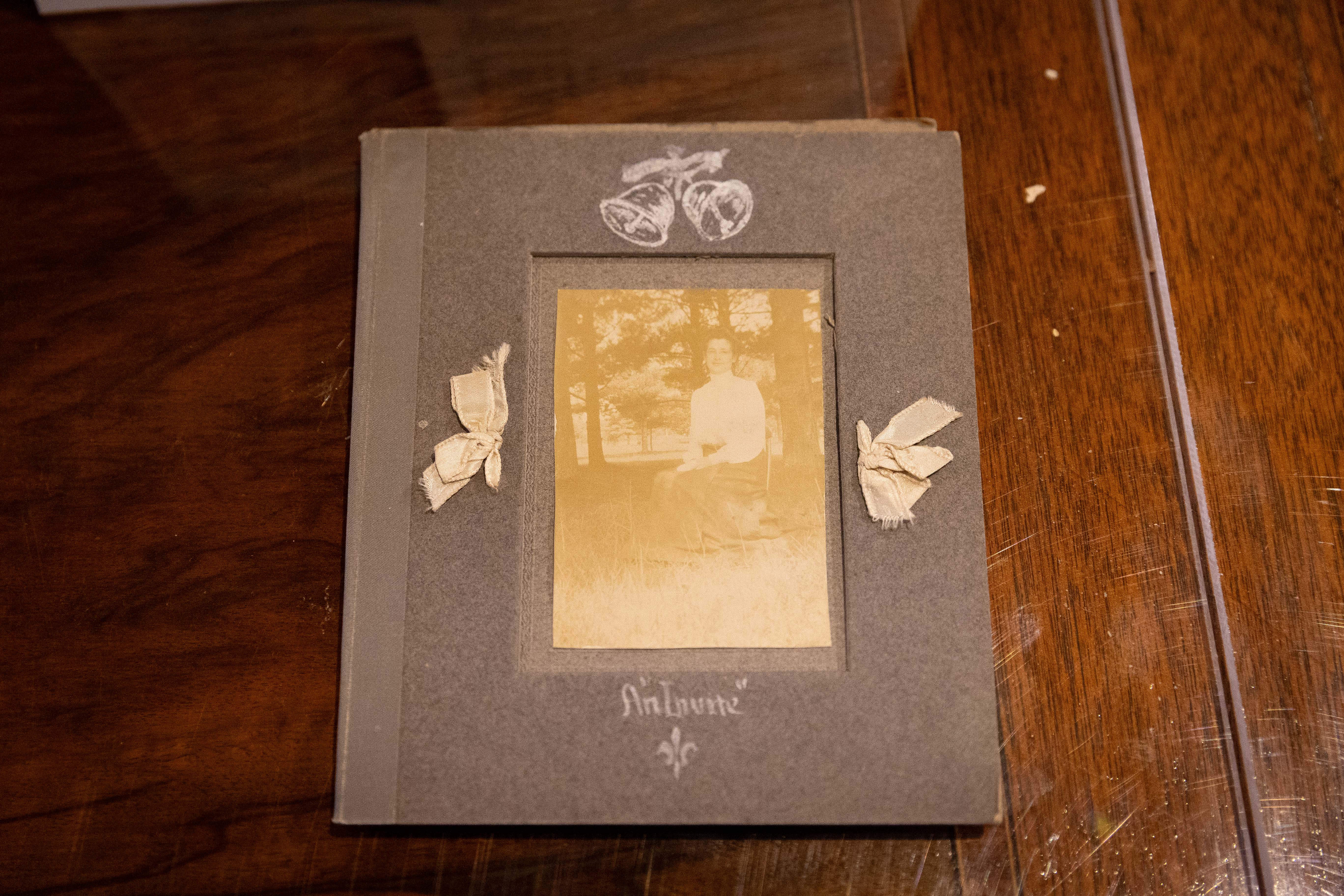 A vintage photo of a person sits inside a book with small bows.