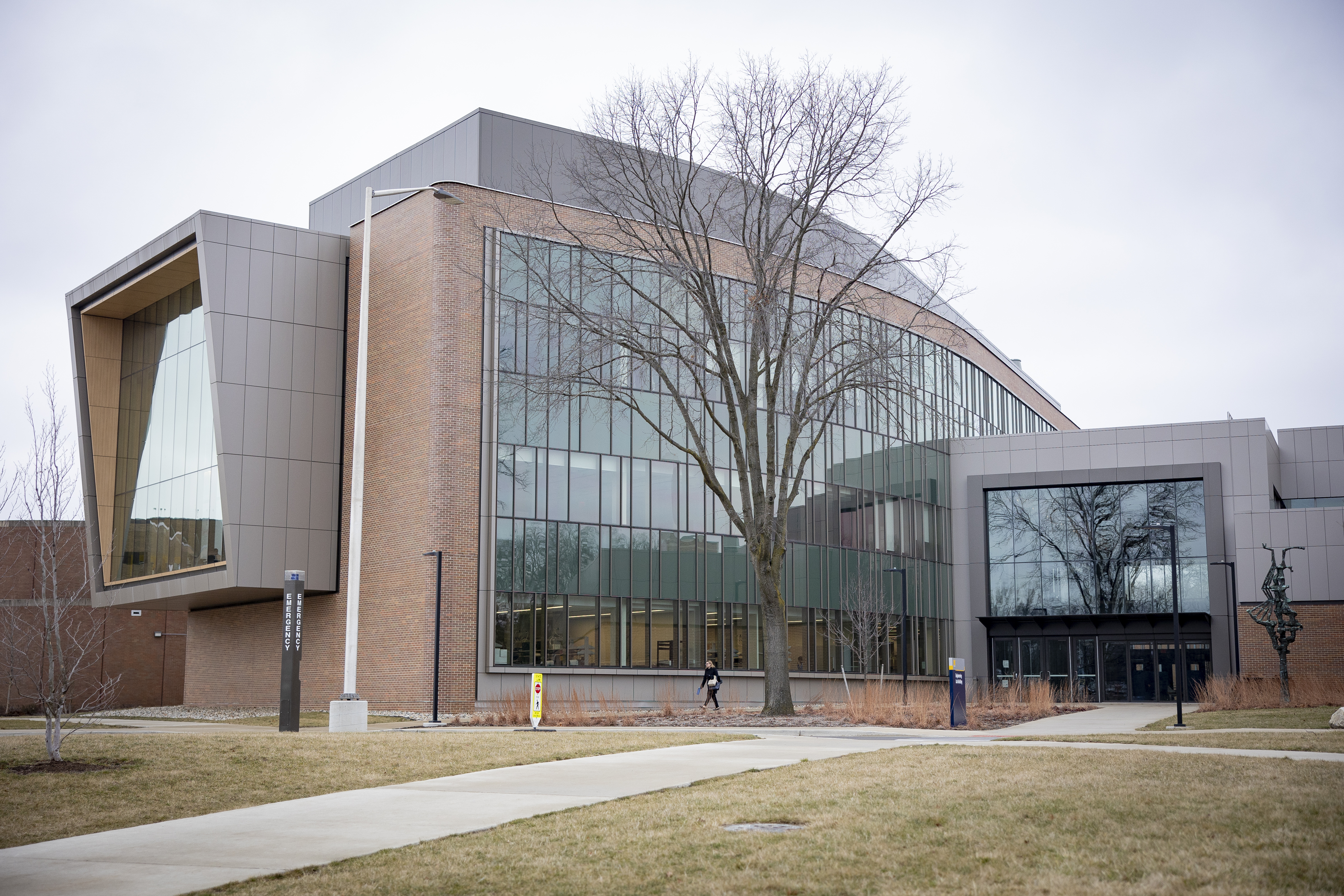 The outside of a large building with a large glass wall and large glass window endcap and entrance.