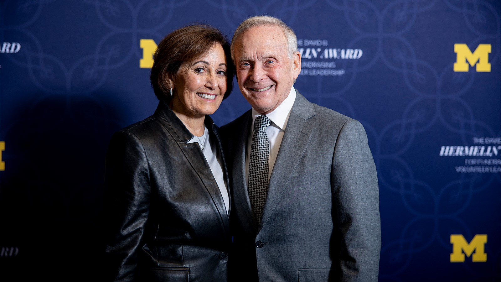 Andrea and Lawrence Wolfe in front of a Hermelin Awards backdrop.