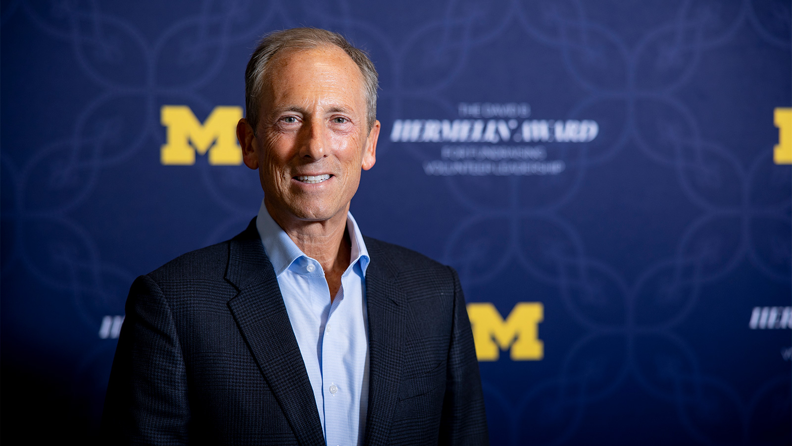 J. David Heller in front of a Hermelin Awards backdrop.