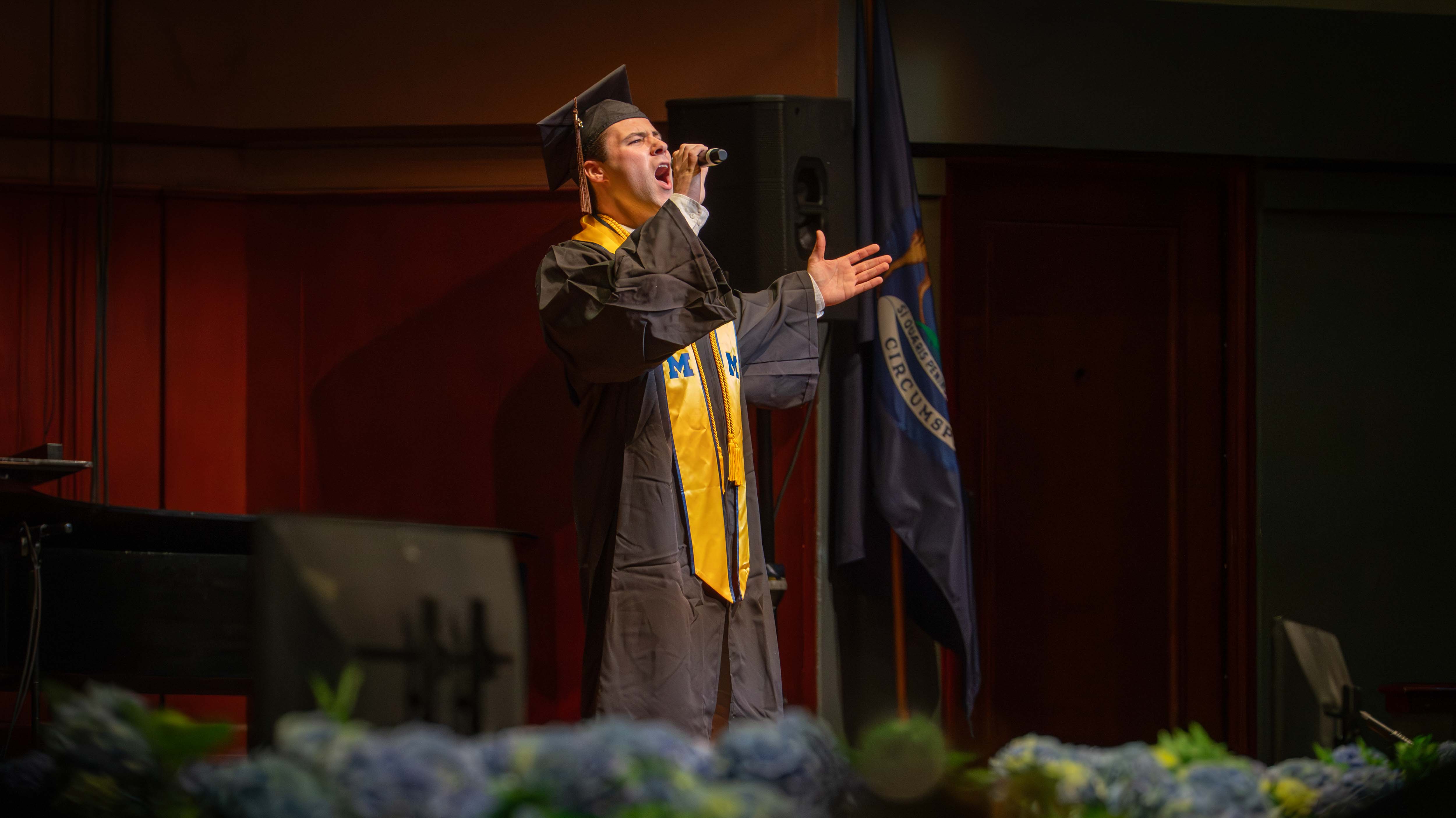  Lleyton Allen singing on stage at the School of Music, Theatre & Dance commencement ceremony at Hill Auditorium.