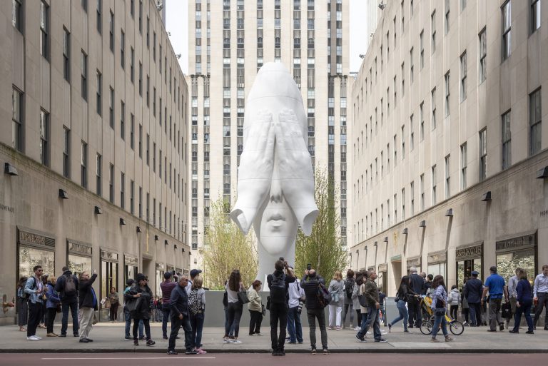 Image of Behind the Walls installation in New York depicting a white sculpture of a man's head with his hands covering his eyes.