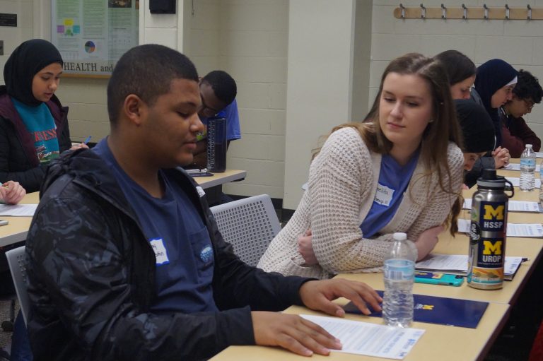 Carmelita talking about health equity with a high school student.