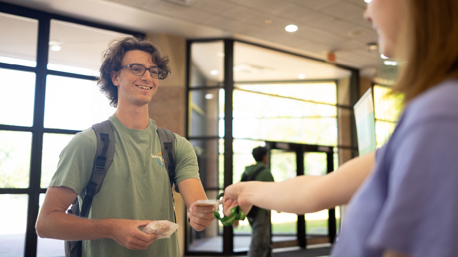 Two students exchanging a piece of swag from CCVP.