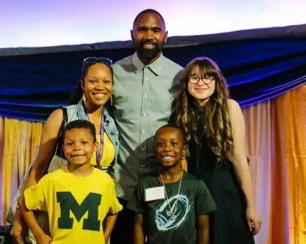 Charles Woodson posing with guests at Event on Main.