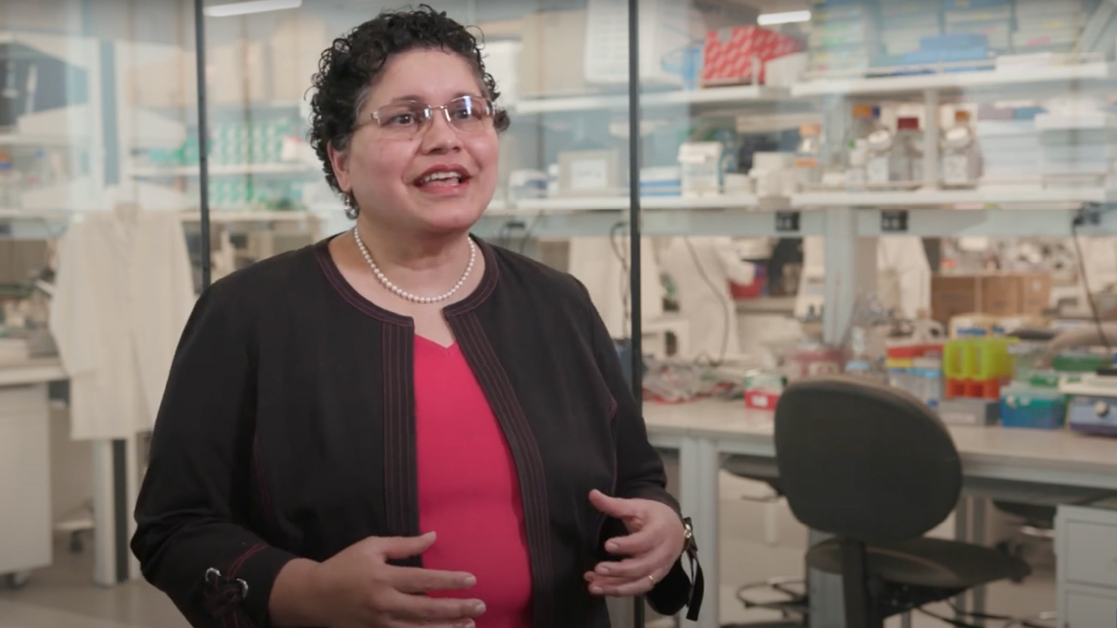 D’Silva standing in the lab, talking through her oral cancer research.