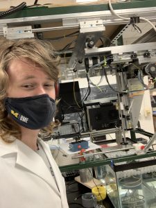 Easton pictured in front of lab equipment.