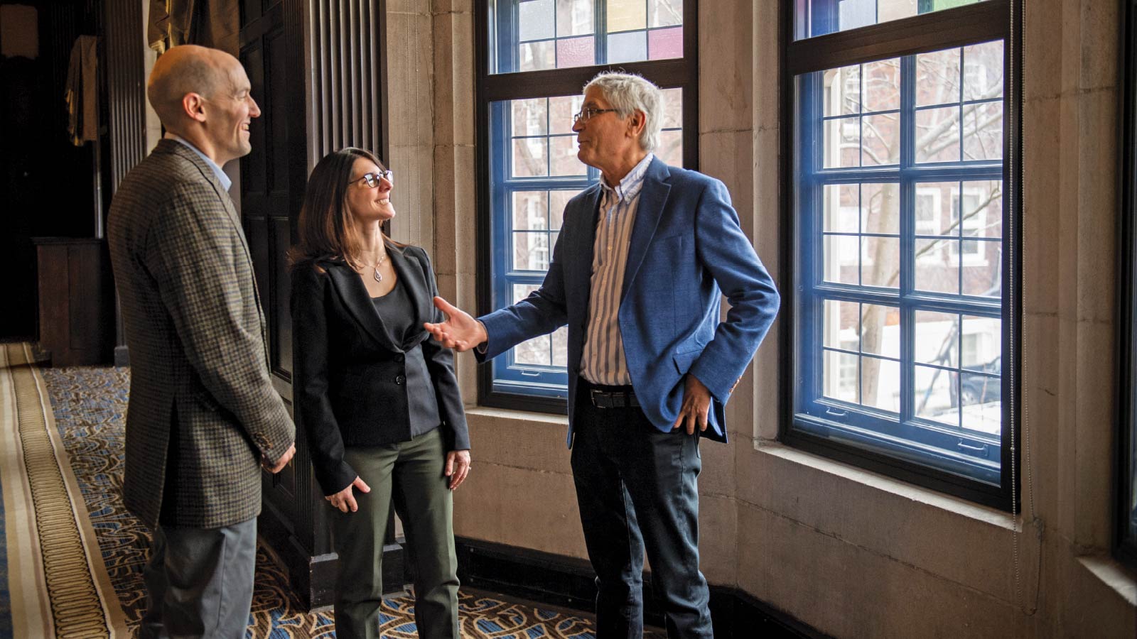 Justin Heinze having a conversation with two colleagues