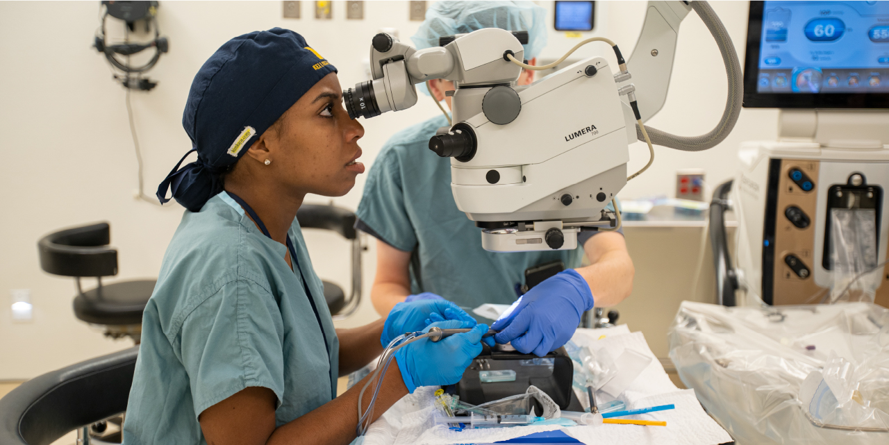 A resident looking through ophthalmology equipment