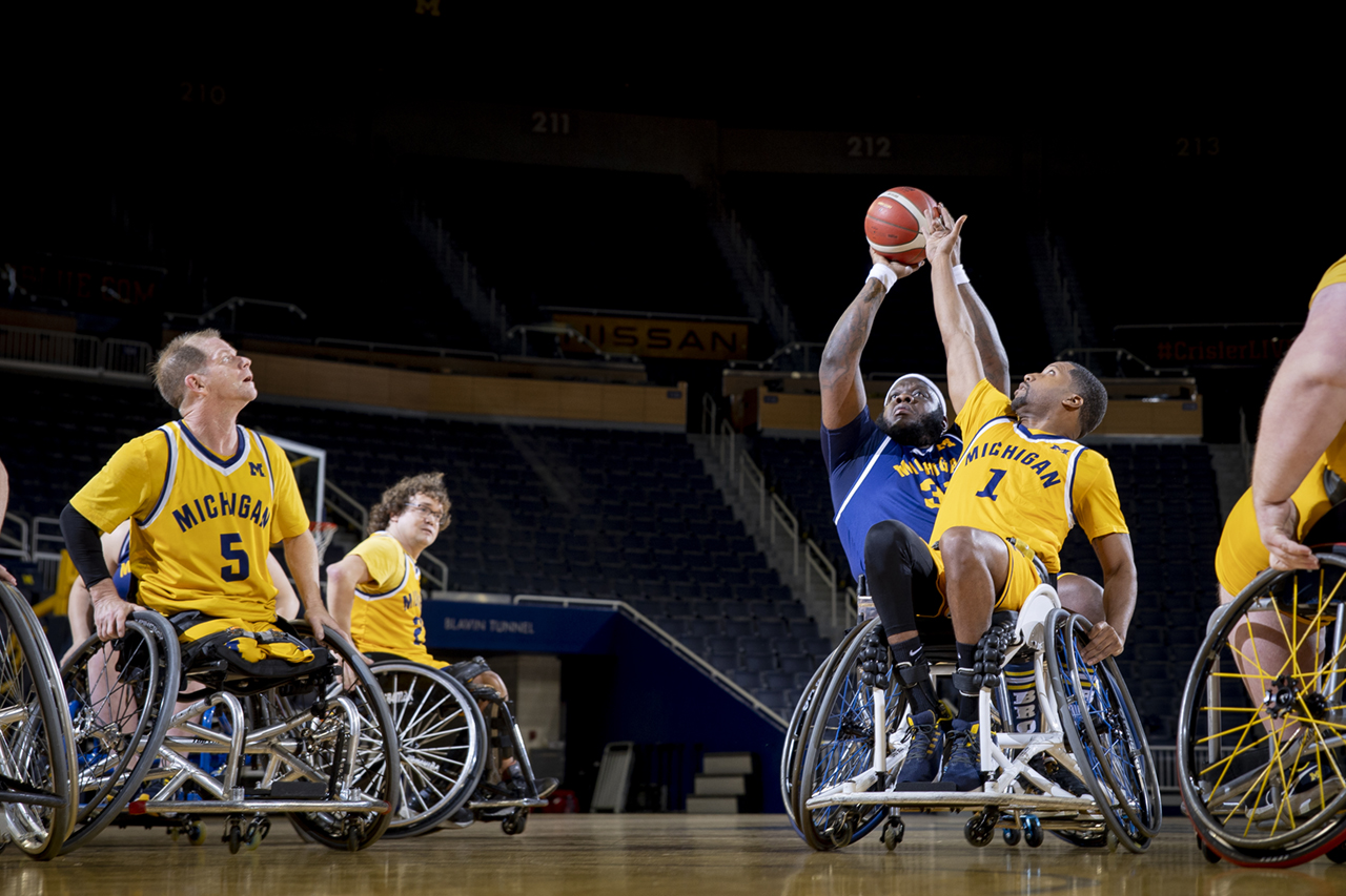 A member of the wheelchair basketball team attempts to block another player’s shot.
