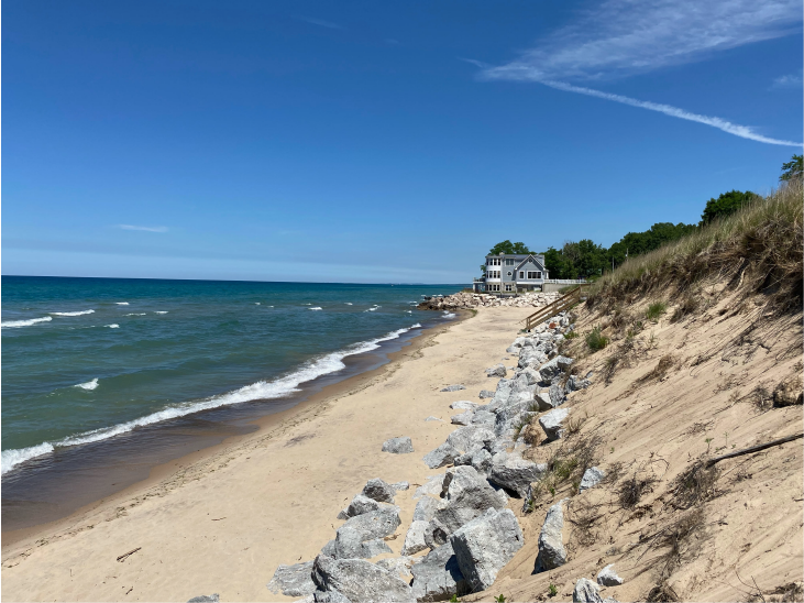 A photo of a beachfront home on Lake Michigan with a seawall around it.