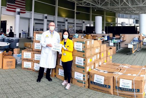 U‑M Professors Joseph Kolars and Amy Huang standing in front of boxes of medical supplies from Michigan Medicine’s partners in China.