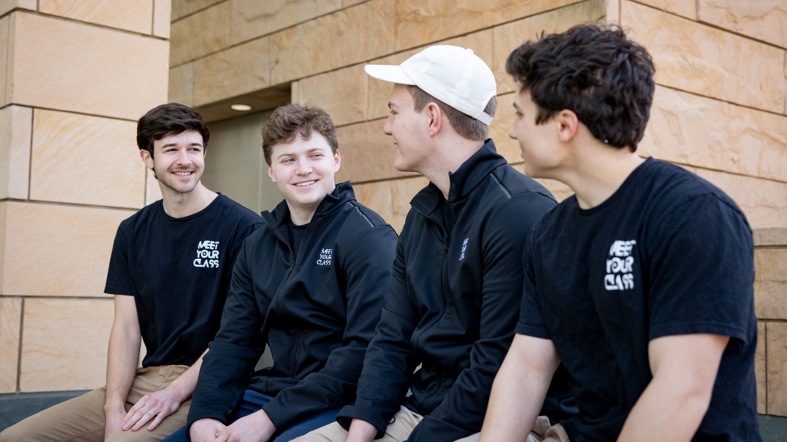 A photo of MeetYourClass founders sitting together for a chat outside of Michigan Ross. 