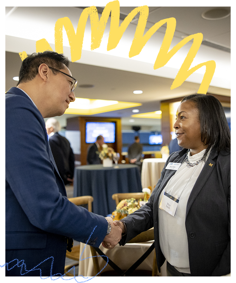 President Ono shaking hands with a woman at an event.