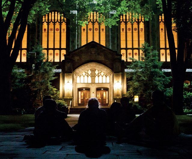 Students silhouetted in front of the Law Quad at dawn.