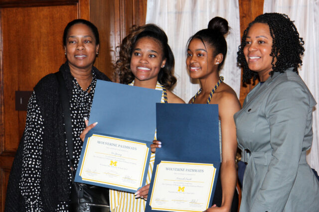 Four women stand side by side, two of whom are Tia Young and Kennedi Smith, who hold certificates. 