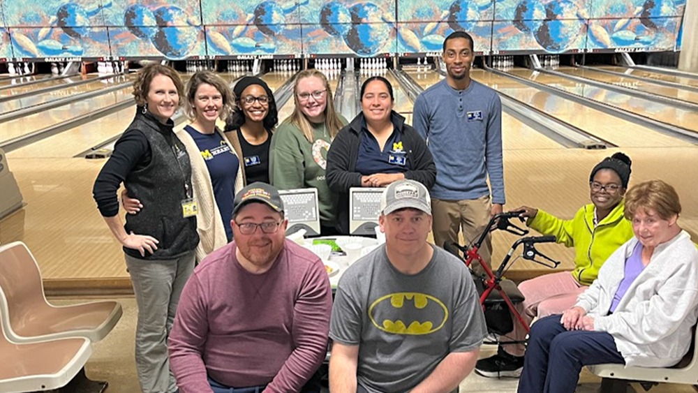 A group of UM-Flint students and faculty with community patients at bowling alley.