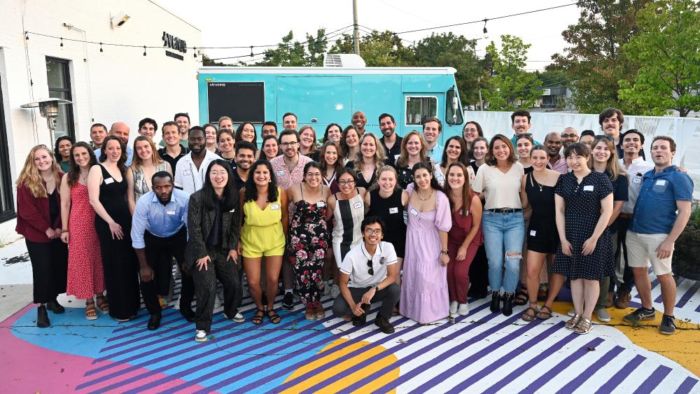 Picture of Erb students, the backdrop is a bright outdoor seating area at a local restaurant.