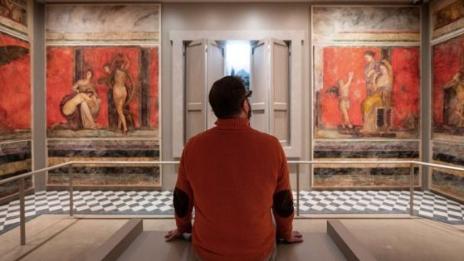 A man sitting in a museum gallery
