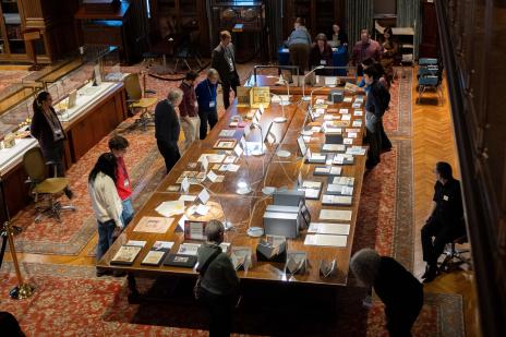 A group of people standing over a large table with artifacts displayed.