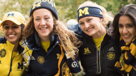 Smiling students in Michigan gear.