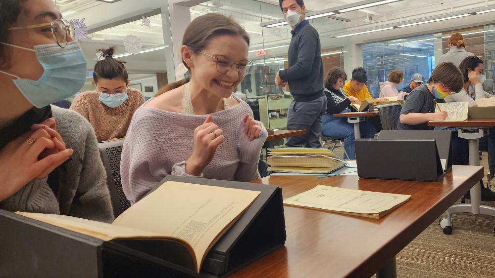 Student smiling looking at materials