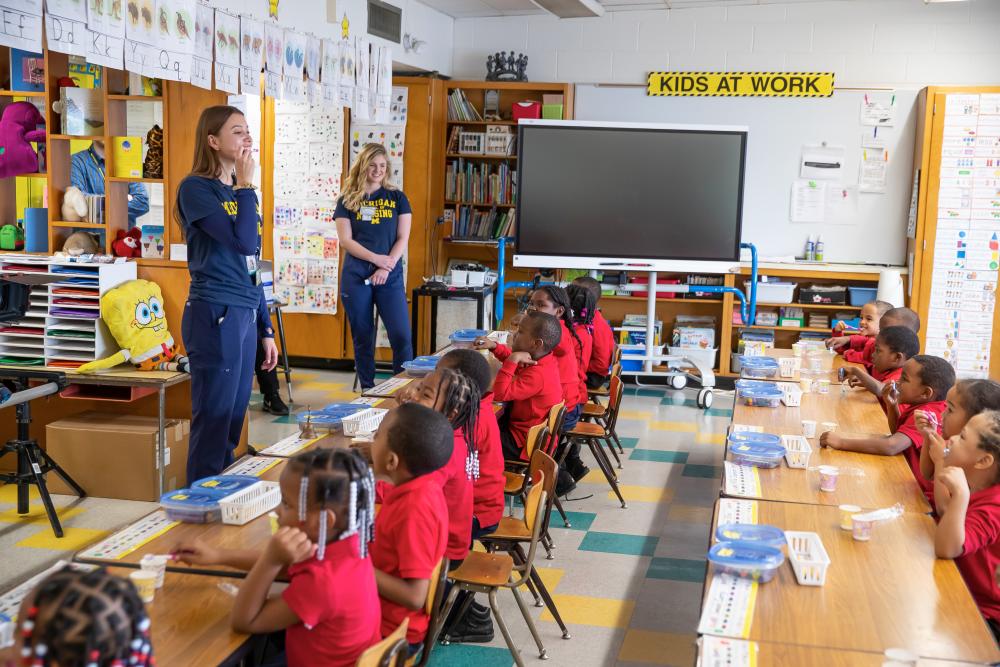 Nursing students teach young elementary students about oral healthy habits