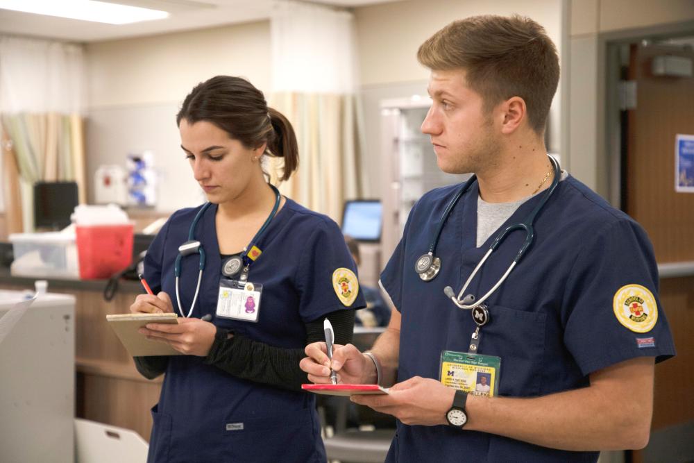 Nursing students take notes on notebooks
