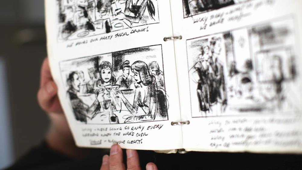 storyboard of scene with two women and a man toasting at a restaurant