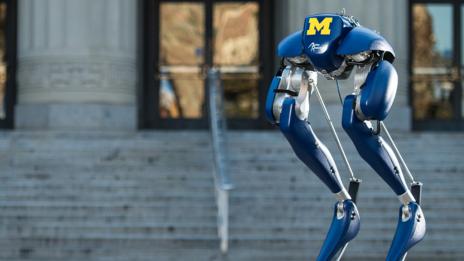 Cassie the robot standing outside of Angell Hall.