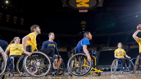 A man preparing to take a shot in a wheelchair basketball game.