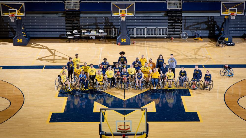 The Adaptive Sports team posing on the Michigan basketball court 