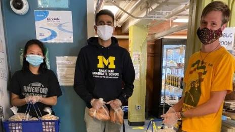 Three students with groceries at the Maize & Blue Cupboard 