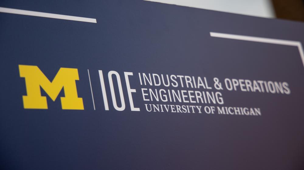 A blue background showcases a yellow Michigan M next to the words IOE Industrial and Operations Engineering University of Michigan